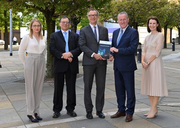 Minister Conor Murphy receiving the final Fiscal Commission report.