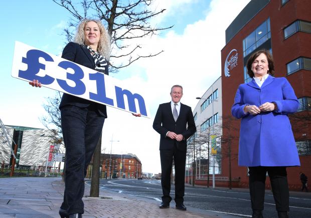 Finance Minister Conor Murphy and Economy Minister Diane Dodds with Louise Ward Hunter from Belfast Met, who is holding a board saying £31m