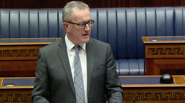 Finance Minister Conor Murphy standing in the NI Assembly Chamber.