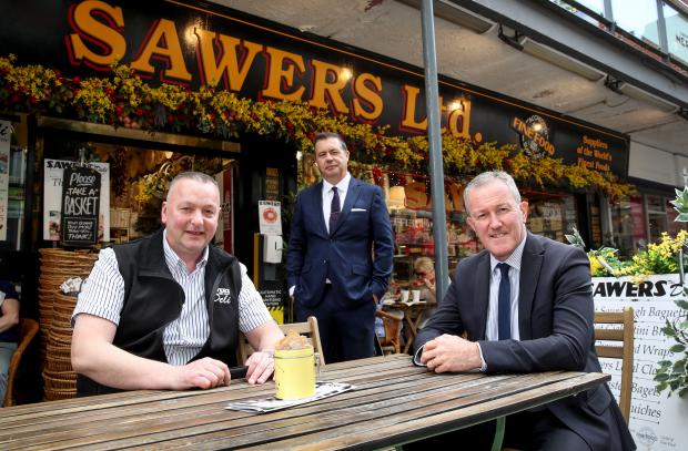 Finance Minster Conor Murphy with shopkeepers in Belfast